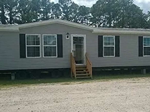 Gray manufactured home with black shutters