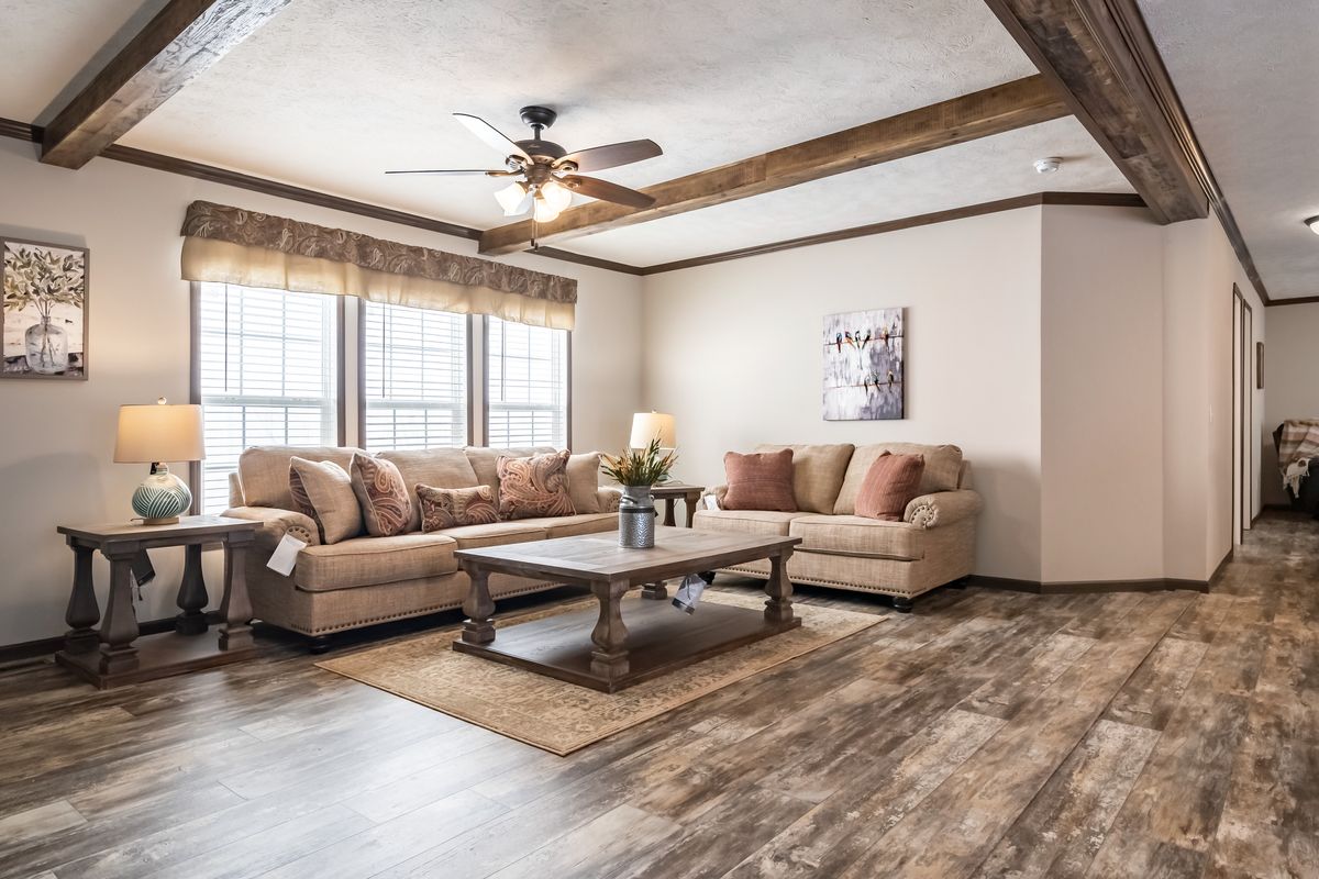 A living room with hardwood floors and a ceiling fan.