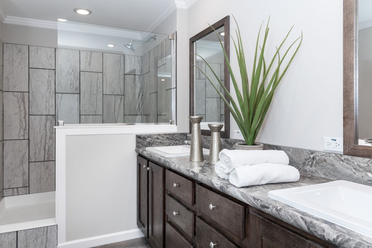 0207f07b-2f4a-44ed-ba5d-402dd64c430c A bathroom with two sinks and marble counter tops.