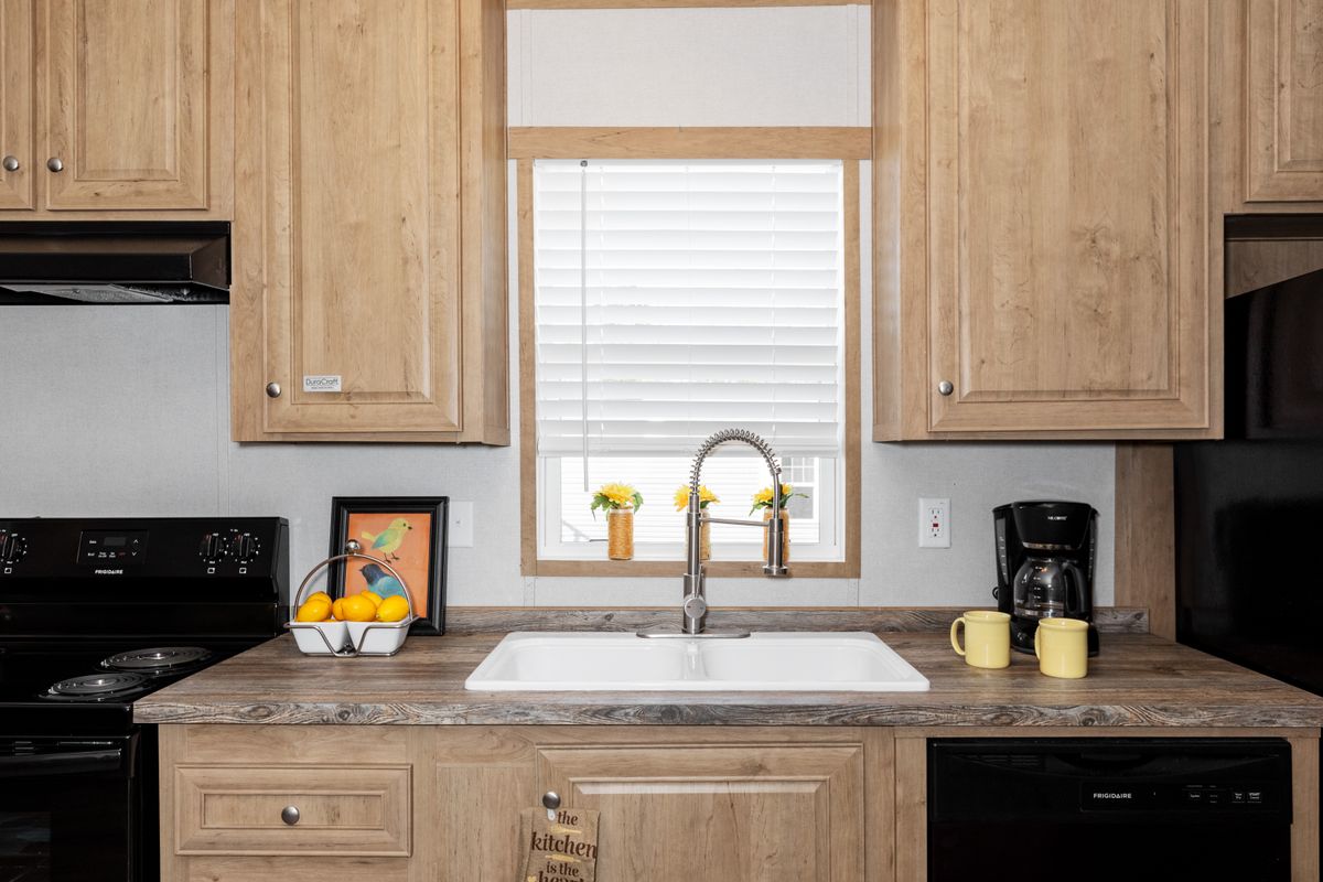 A kitchen with wood cabinets and a sink.