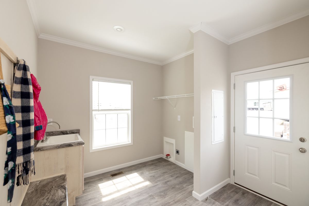 0662b6d4-8844-4233-b344-86ad3caa545d A laundry room with a wooden floor and a door.