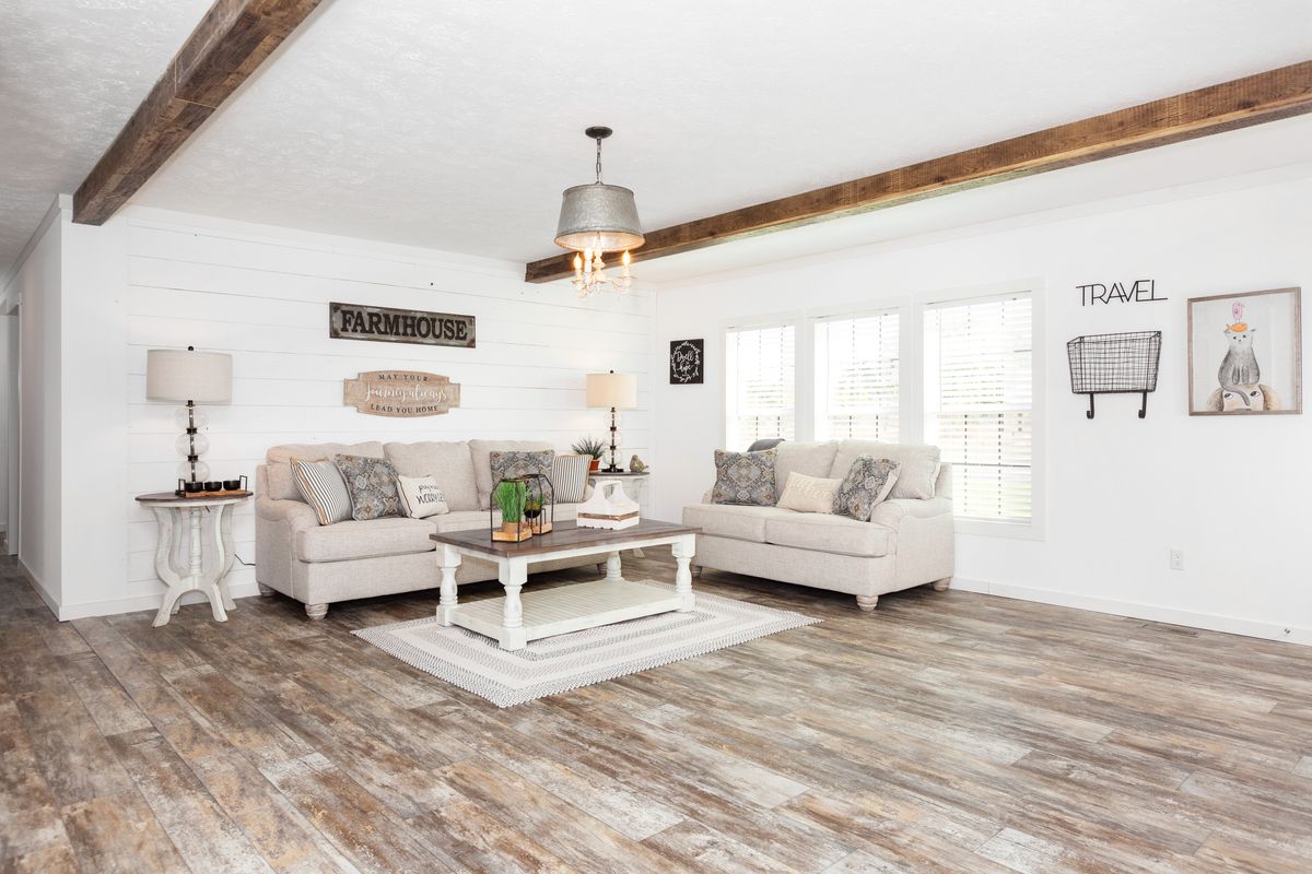 A living room with wood floors and beams.