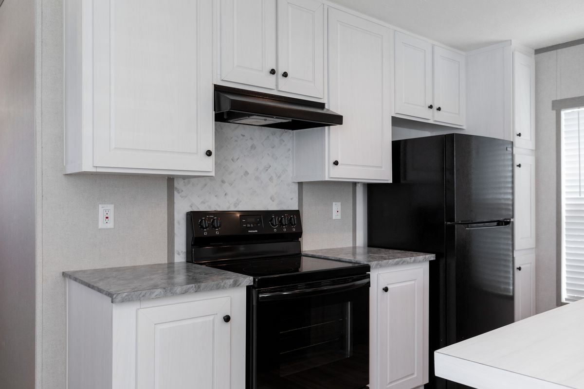 0b16e13b-b966-4ea7-a8fc-7c2b532afa90 A kitchen with white cabinets and black appliances.