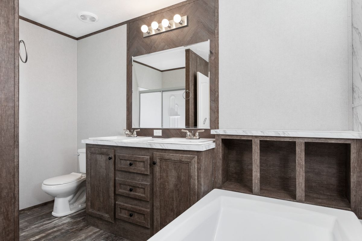 A bathroom in a mobile home with a tub and sink.