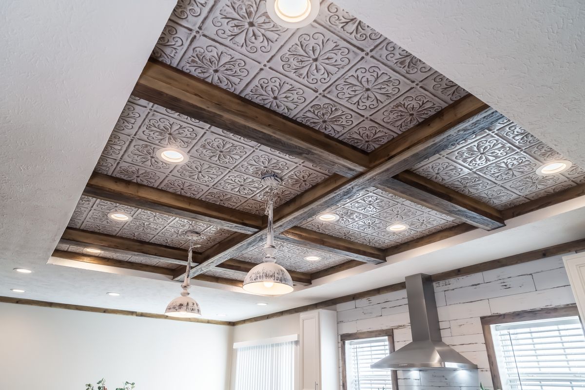 Tin ceiling in a kitchen with wood beams.