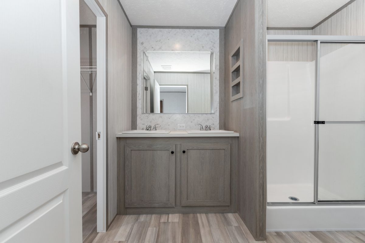 0e4059de-3a34-4e0b-aae1-90d7f4d42d2f A bathroom with a walk in shower and a sink.