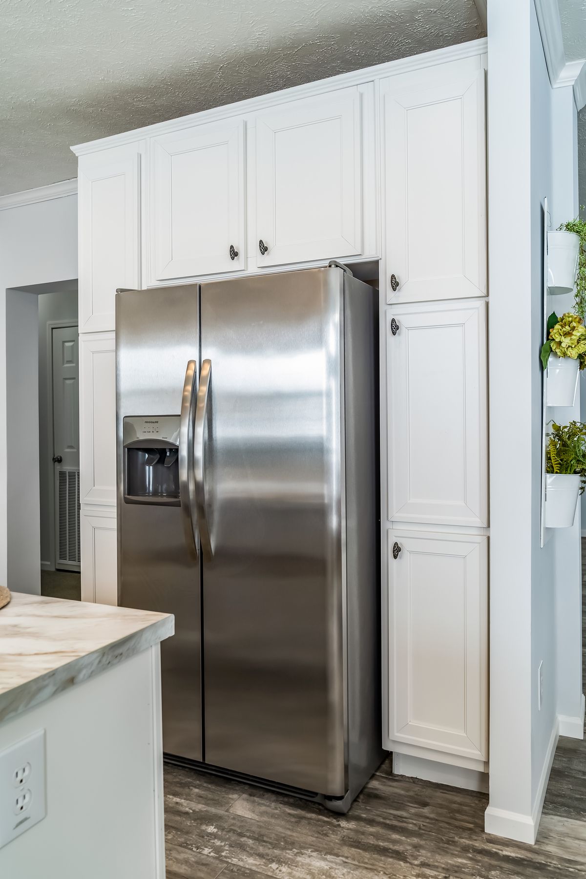 0ec5329b-fcd5-40ed-8f07-3cb64e76e101 A kitchen with white cabinets and stainless steel appliances.