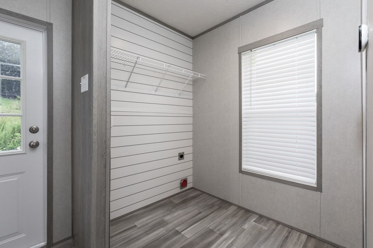 1349a2f2-54bf-4bb6-954f-704f68389a77 The interior of a mobile home with white walls and wood floors.