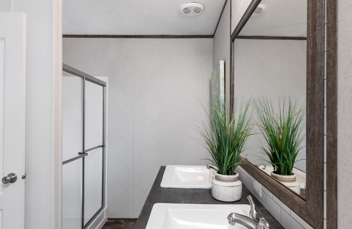 A bathroom with two sinks and a mirror.