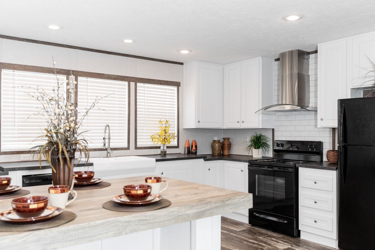 A kitchen with white cabinets and black appliances.
