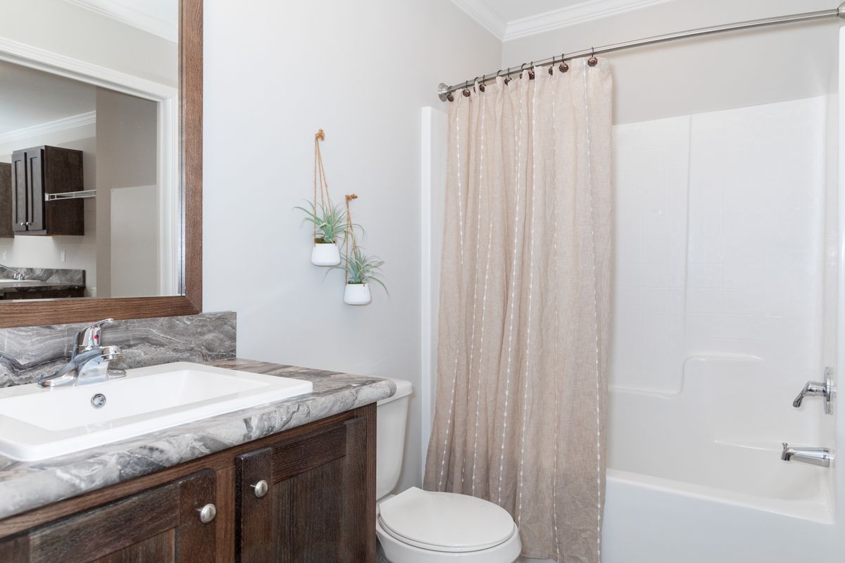 17d3d910-6882-4ab6-90cb-7f7eac59b21e A bathroom with a toilet, shower, and sink.