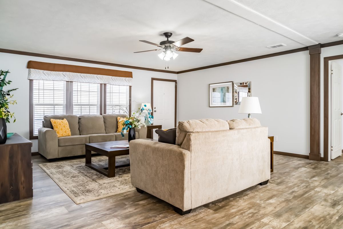 A living room with hardwood floors and a ceiling fan.
