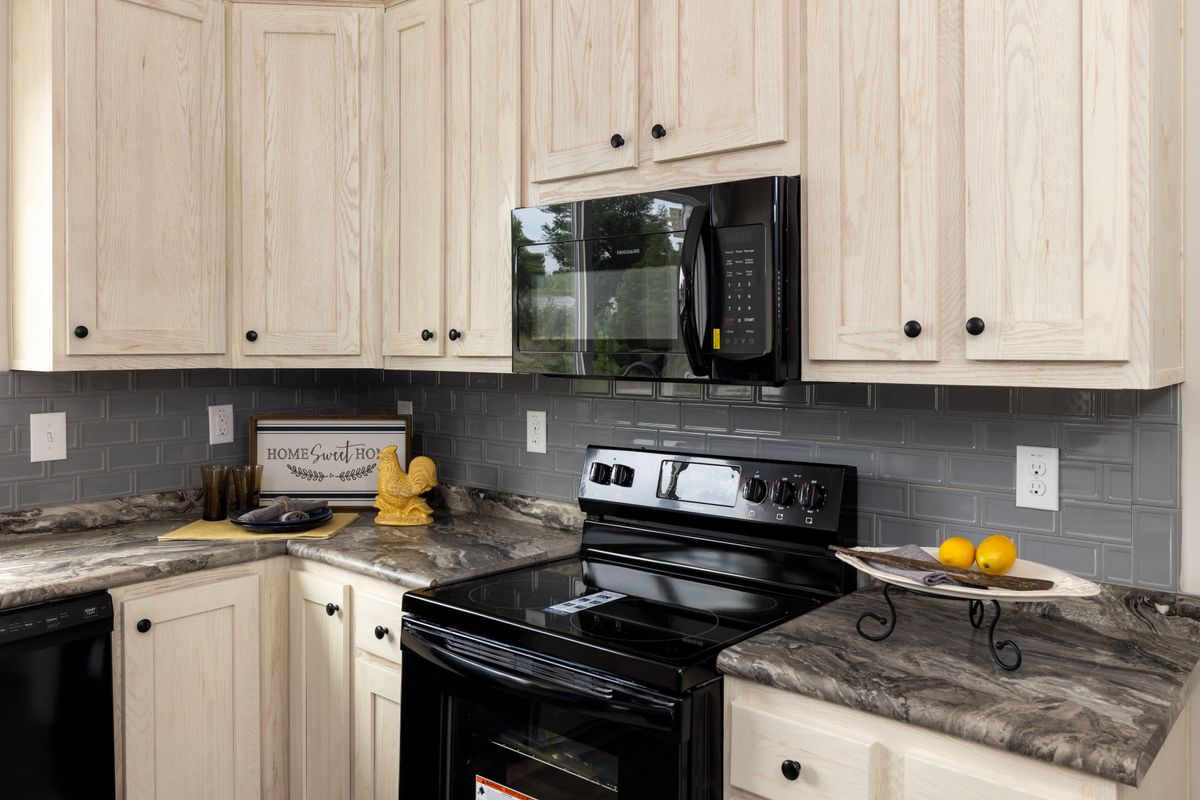 1c16e35f-b1ec-4659-841e-a3dab0361826 A kitchen with white cabinets and black appliances.