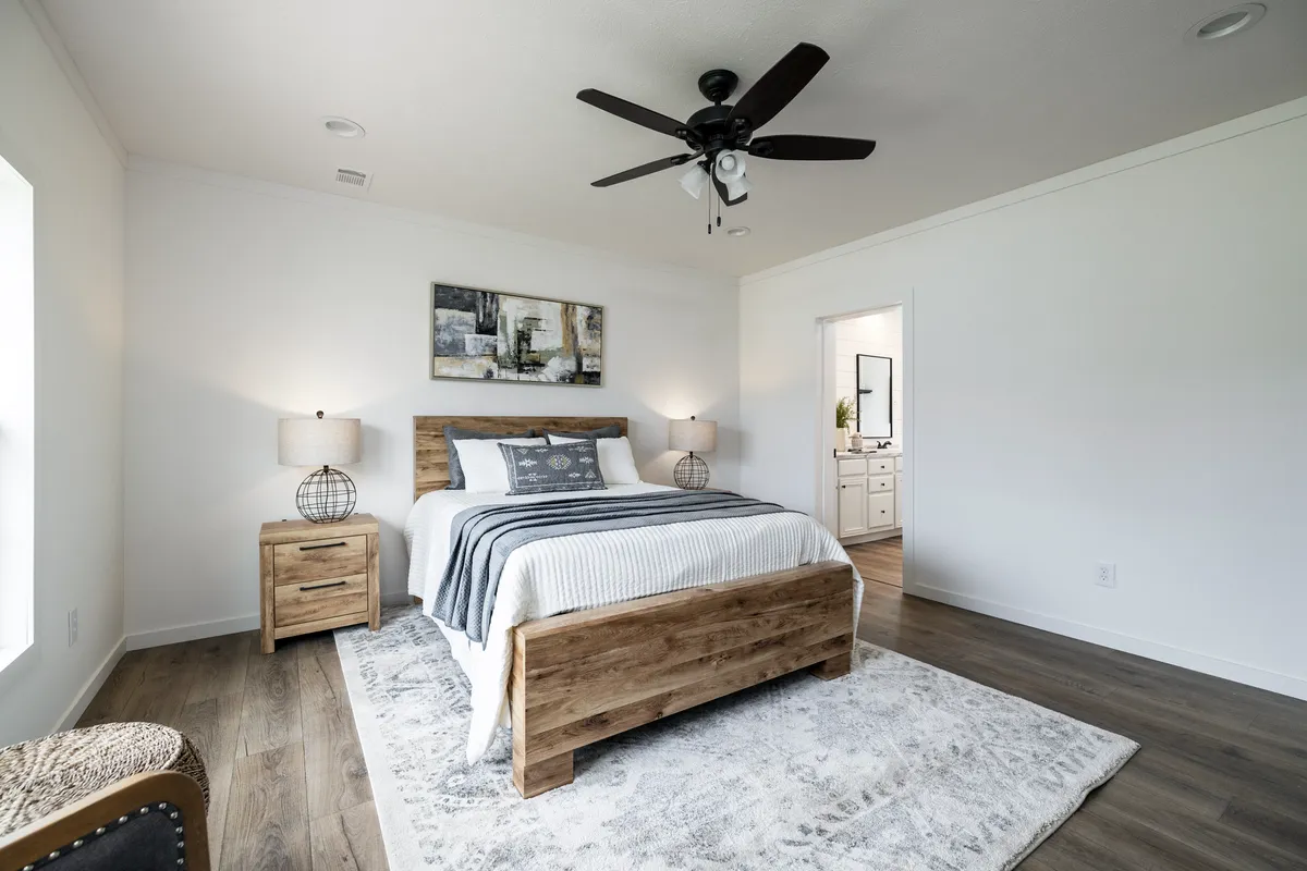 1d1c12ae-bd53-4add-83b6-1063809a3cbd A bedroom with hardwood floors and a ceiling fan.