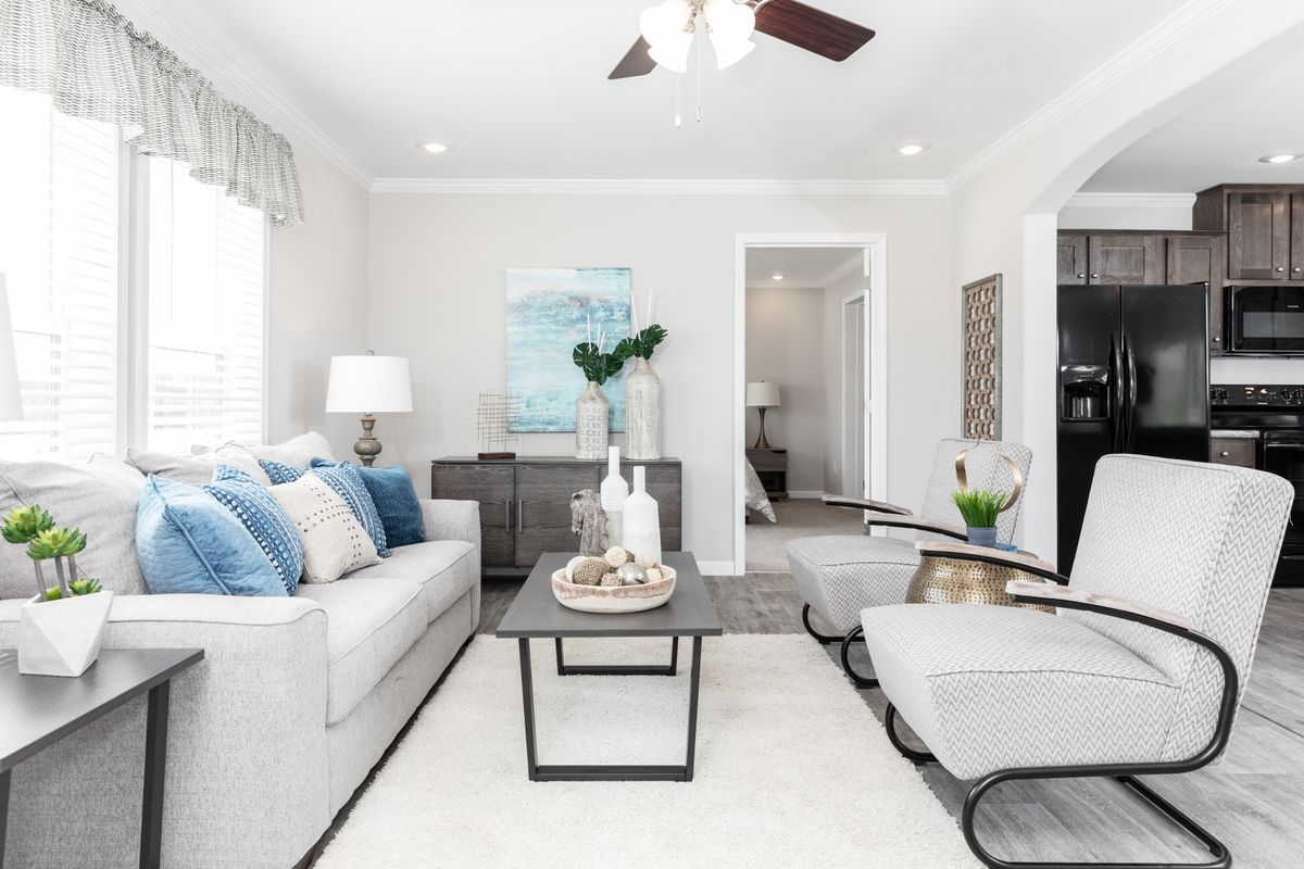 1dafd405-182f-4342-a445-993c8c31e697 A living room with gray furniture and a ceiling fan.