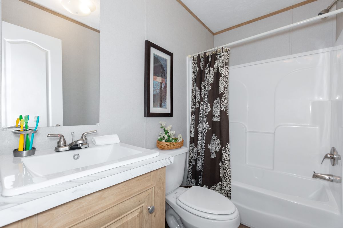 A bathroom with a toilet, sink and shower.