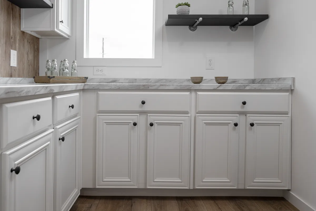 20dd666c-7361-4e69-a7a1-fd7c7f5594b8 A kitchen with white cabinets and wood floors.