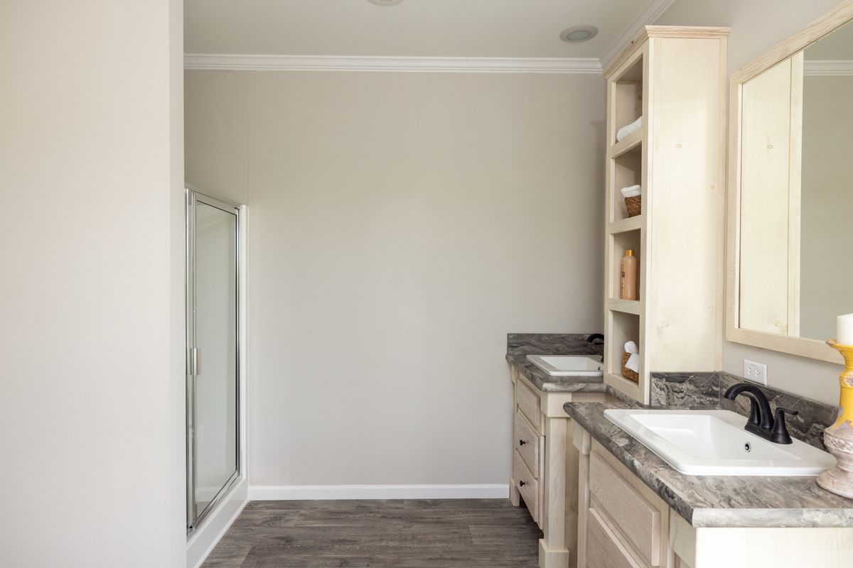 214f8564-48b9-4ec7-8a91-0a9ab05b0f71 A bathroom with two sinks and a walk in shower.