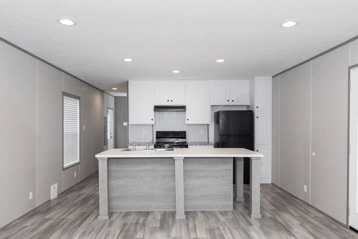 25835e62-7f86-4f50-a87c-91b6bac3f476 A mobile home with a kitchen and living room.