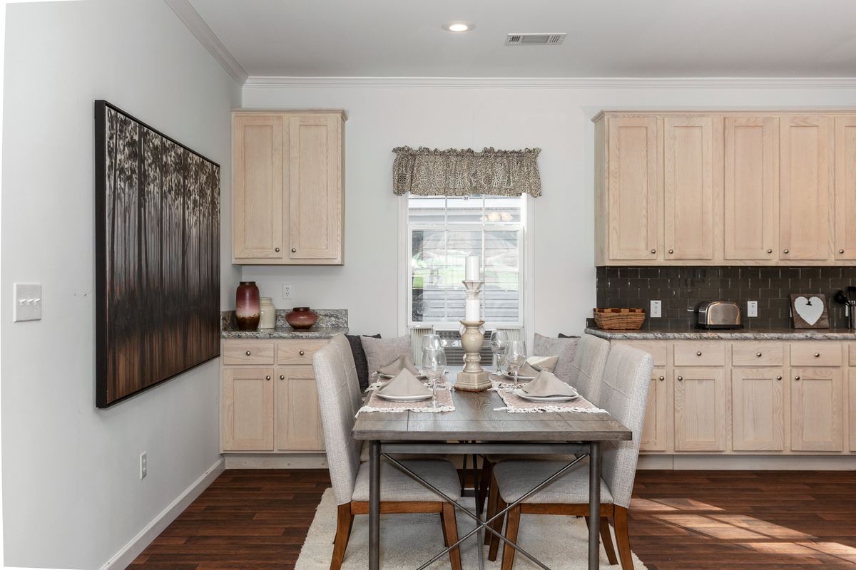 A kitchen with wood cabinets and a dining table.