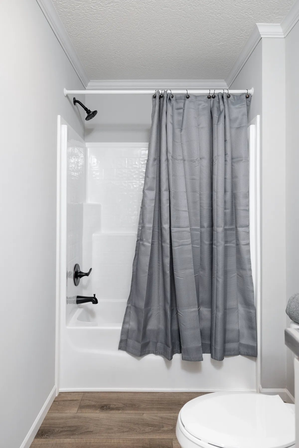 A bathroom with a gray shower curtain.