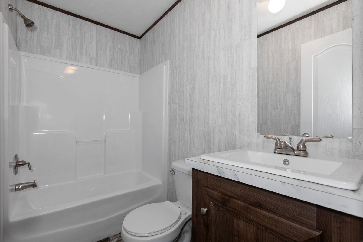 A bathroom with a toilet, sink and shower.