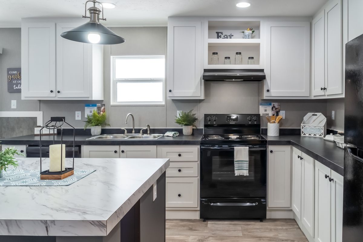 A kitchen with white cabinets and black appliances.