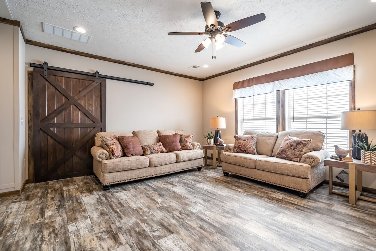 A living room with hardwood floors and a ceiling fan.