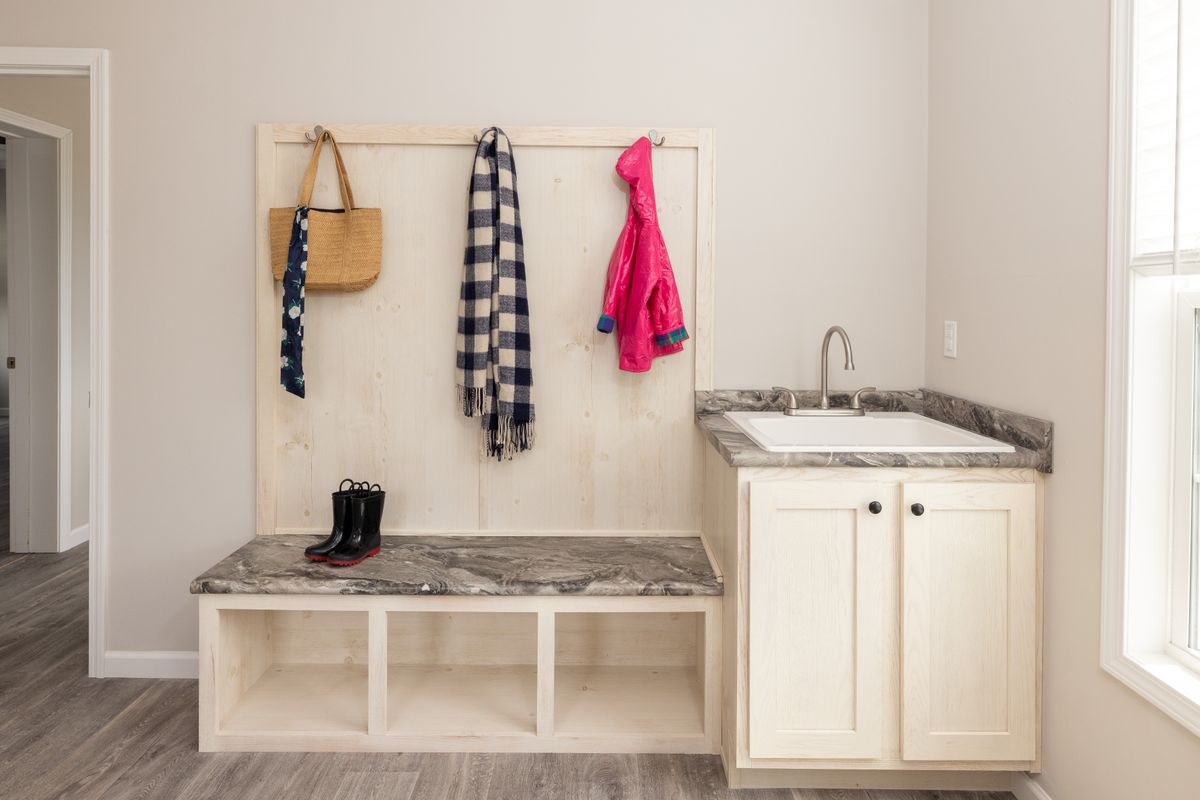 2ad5992a-3e81-422e-bae2-e90f667e0bf3 A small bathroom with a sink and a coat rack.