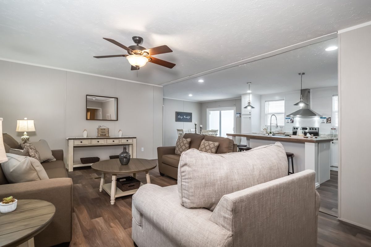 A living room with couches and a ceiling fan.