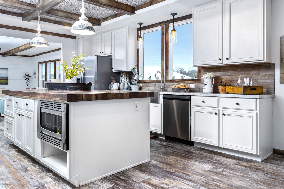 A kitchen with wood beams and white cabinets.