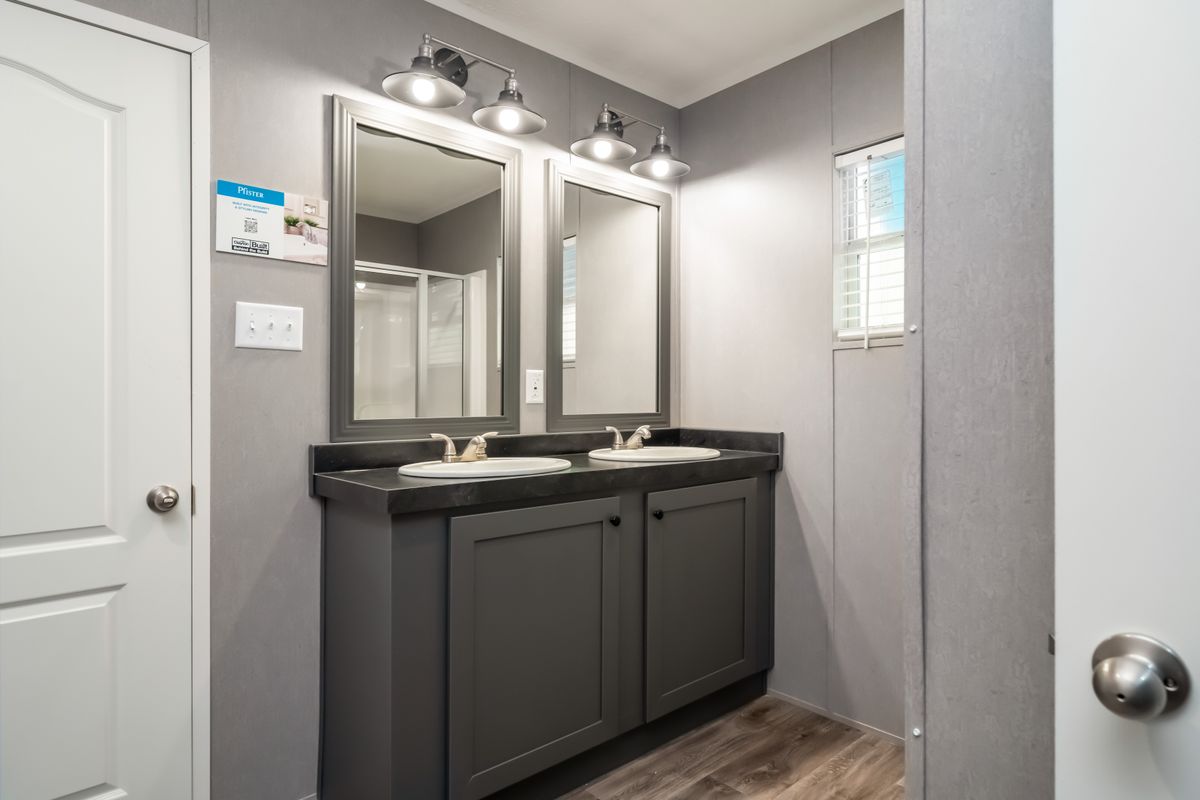 2ea1bec2-bffb-4e53-8e49-3d7390a787a9 A bathroom with two sinks and a mirror is designed for convenience and functionality.