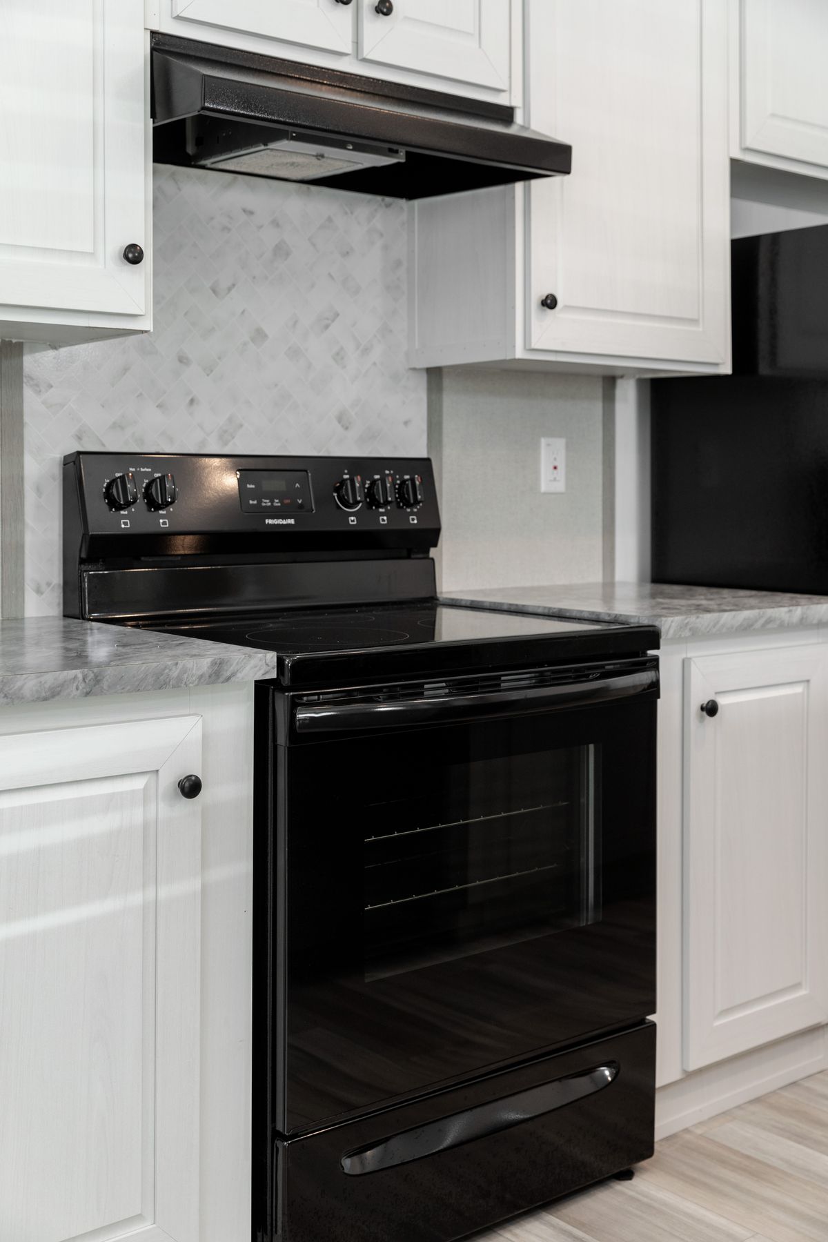 315a84f6-24ec-44ed-9418-dda923a1e407 A kitchen with black appliances and white cabinets.