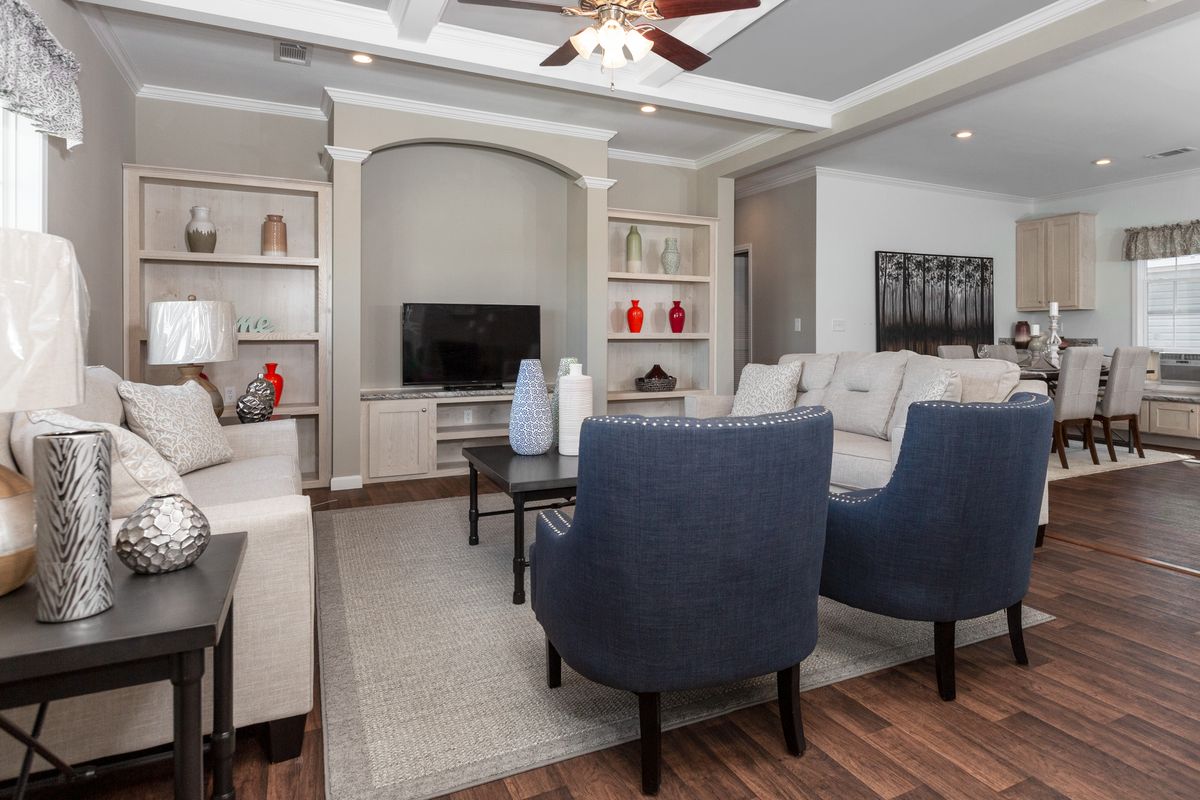 A living room with hardwood floors and a ceiling fan.