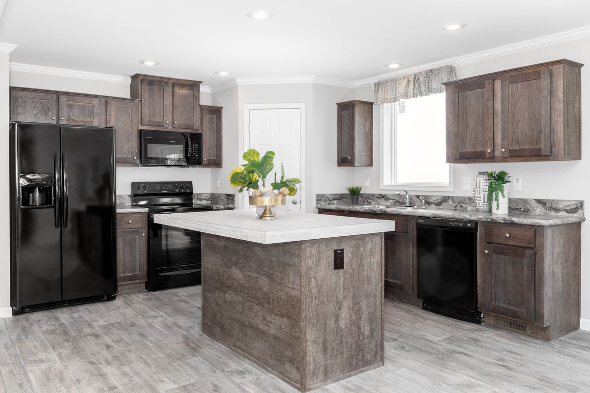 33fa8e6a-4977-4930-a395-9eed27f12a56 A kitchen with wood cabinets and stainless steel appliances.
