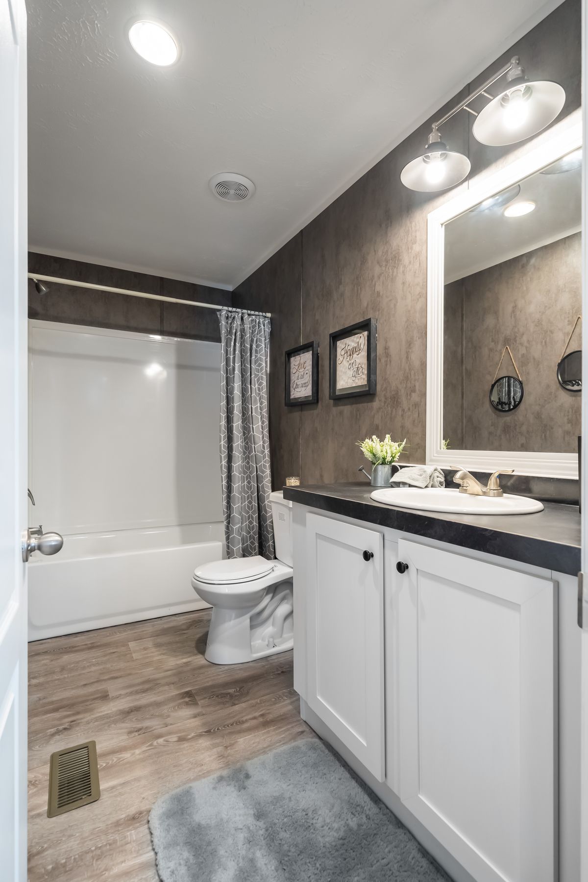 A bathroom with white cabinets and a sink.