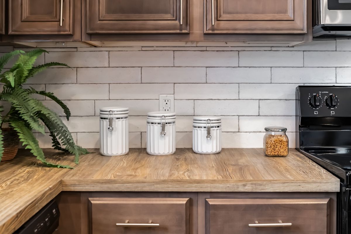 A kitchen with wood cabinets and a potted plant.