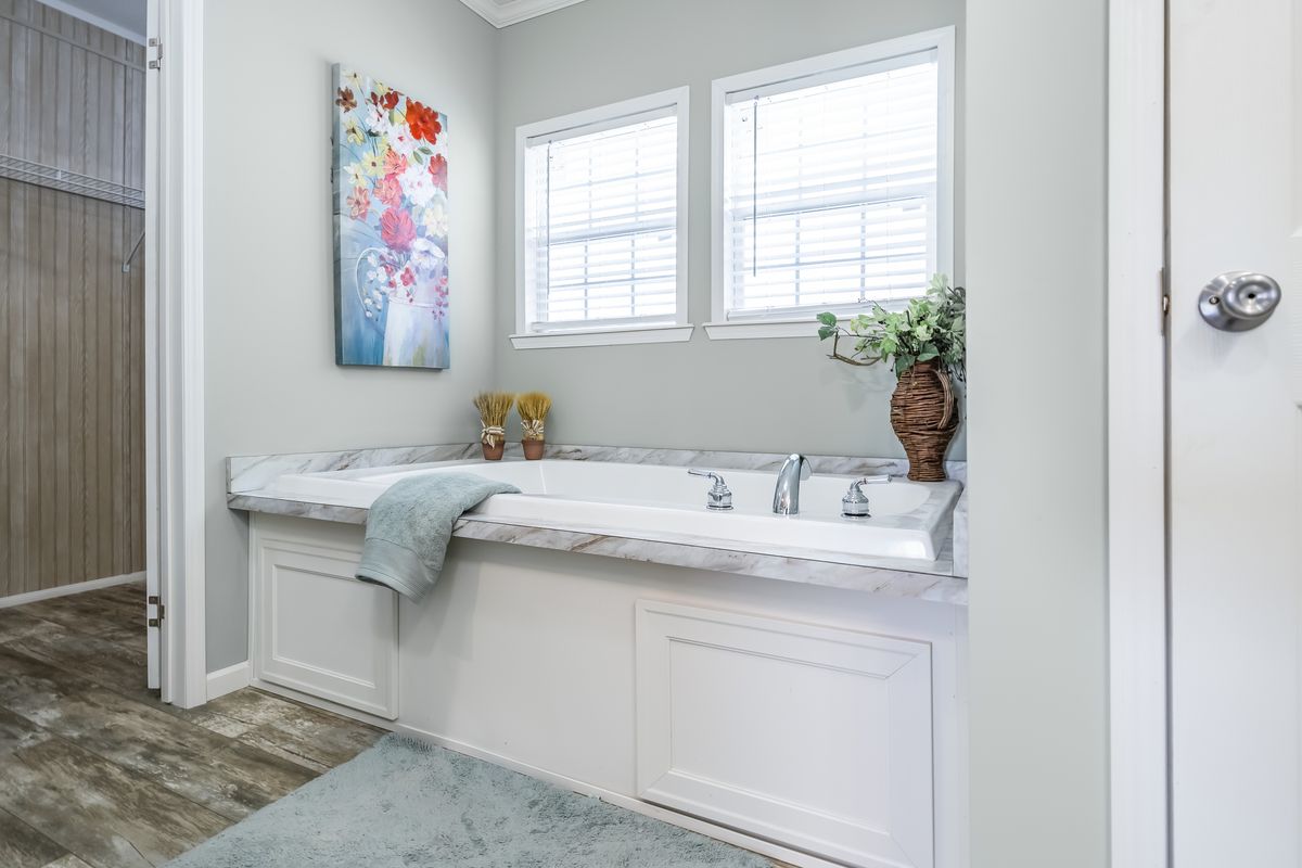 3990600d-dbb2-4869-be34-2030926b4745 A bathroom with a tub and a painting on the wall.