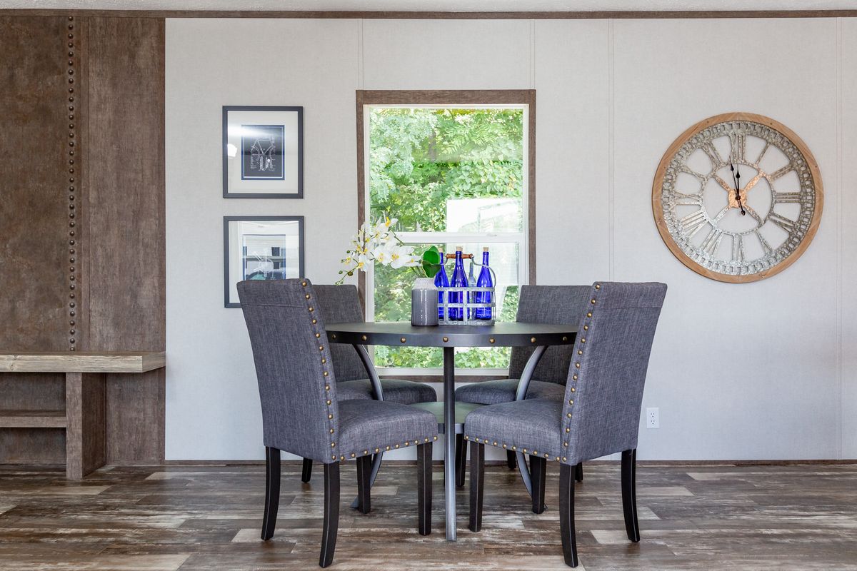 3c526e4d-abdf-44c8-9d25-3196d84c0234 A dining room in a mobile home with a clock on the wall.