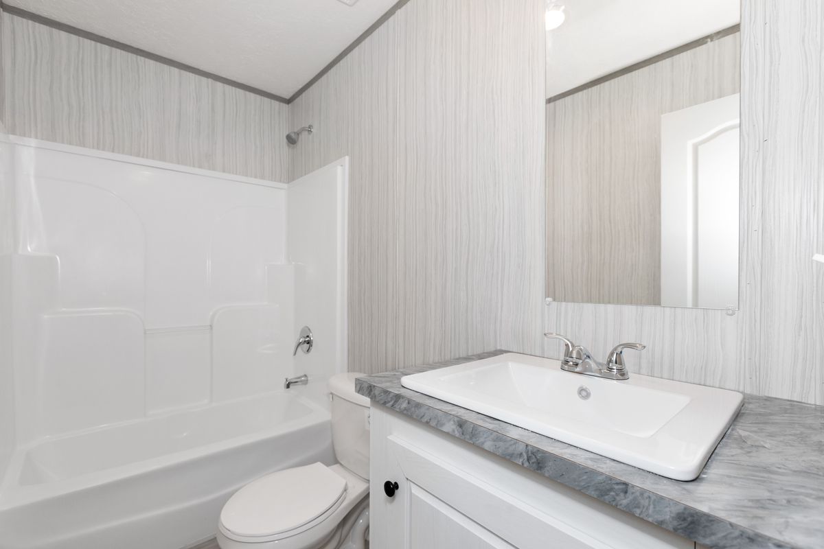3ca21de6-e9ed-474e-b9d9-1b2e4992caa0 A bathroom with a sink, toilet and shower.