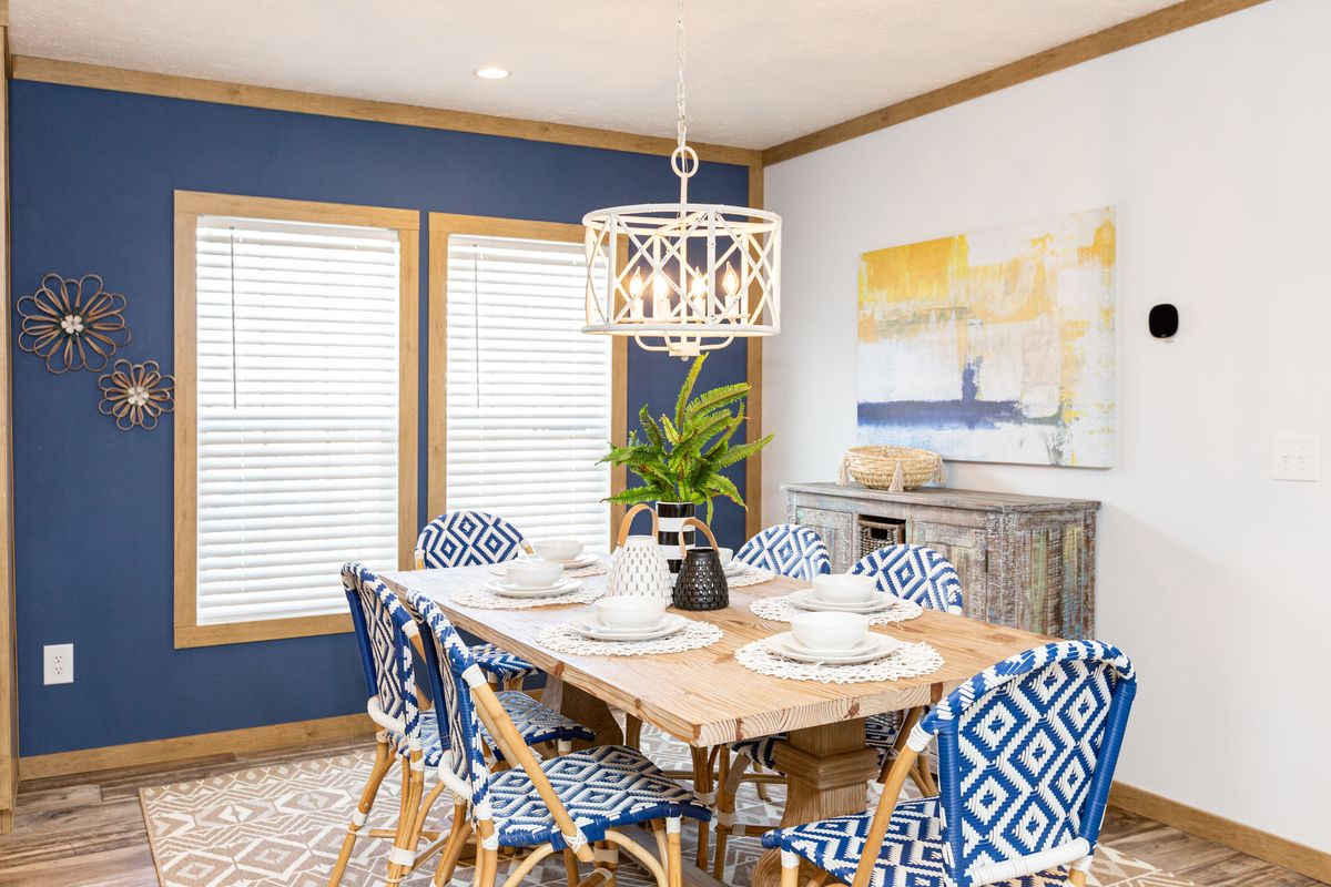 A dining room with blue walls and blue chairs.