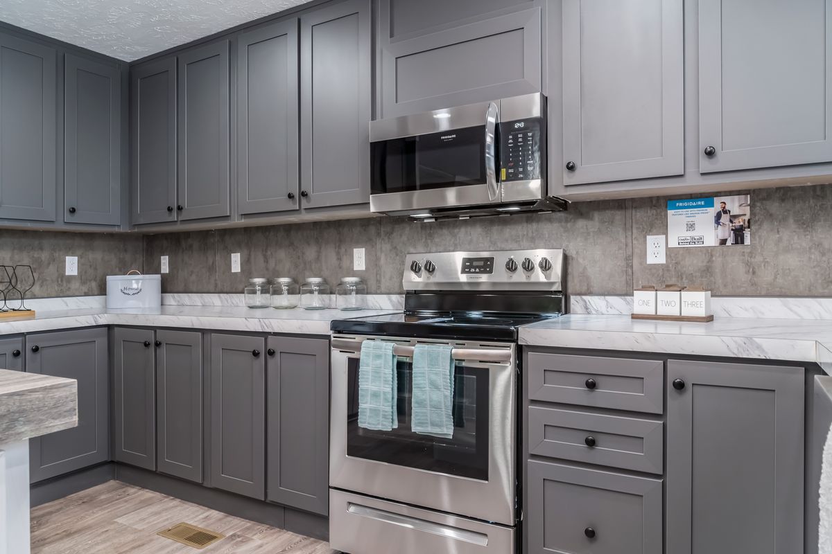 43c48733-ad05-4e81-9ebe-a20f0f27b9a7 A kitchen with gray cabinets and stainless steel appliances.