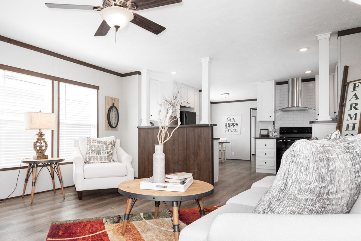 A living room with hardwood floors and a ceiling fan.