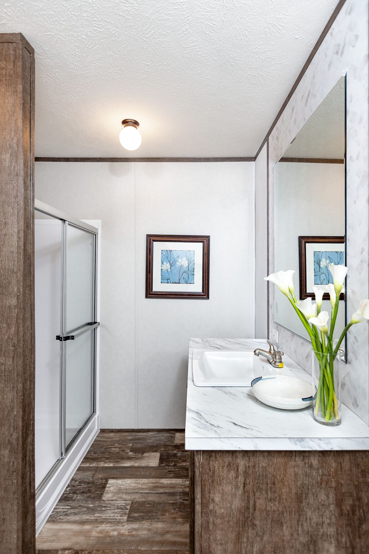 4687ce67-a56e-44e3-8785-06bdff6f13c7 A bathroom with a sink, toilet and shower.