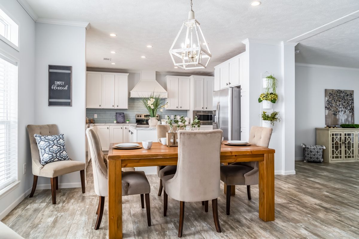 4a37e5b9-c18f-4971-9d15-02d2b7bc9392 A white kitchen and dining room with hardwood floors.
