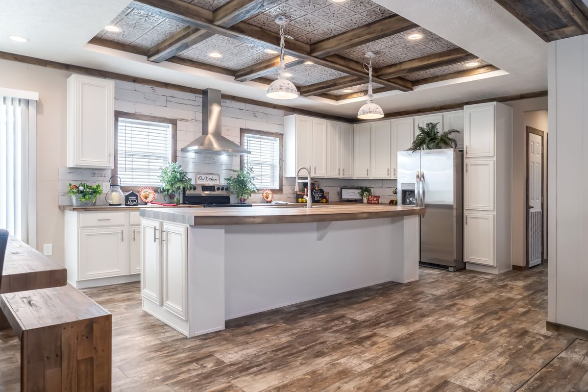 A white kitchen with wood floors and wood ceilings.