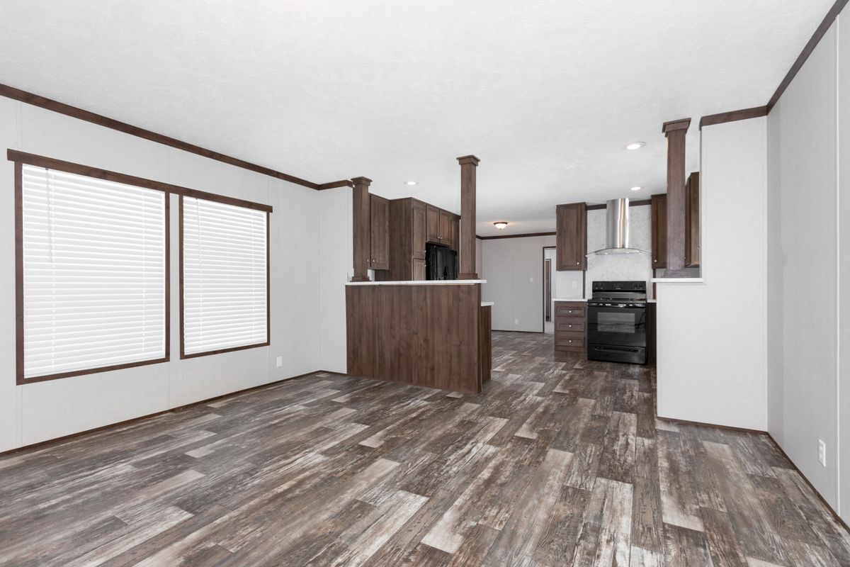 The living room of a mobile home with wood floors.