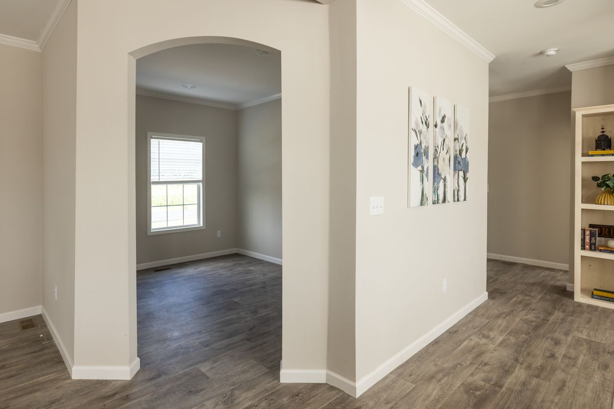 4b1c329f-e38b-42ab-953e-1b3bda853599 A living room with hardwood floors and a bookcase.
