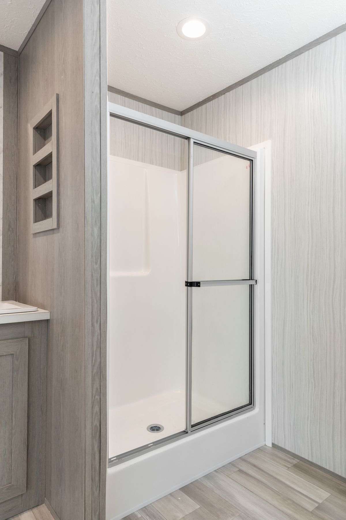 4c50079c-093d-45c3-8127-b90667a5d132 A bathroom with a glass shower and wood floors.