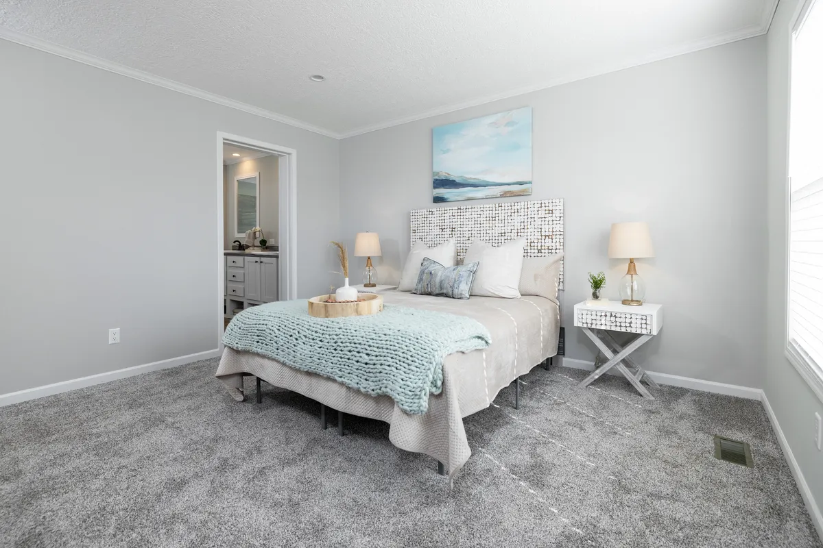 A gray bedroom with a bed and a dresser.